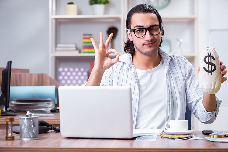 freelancer on laptop holding his tax refund