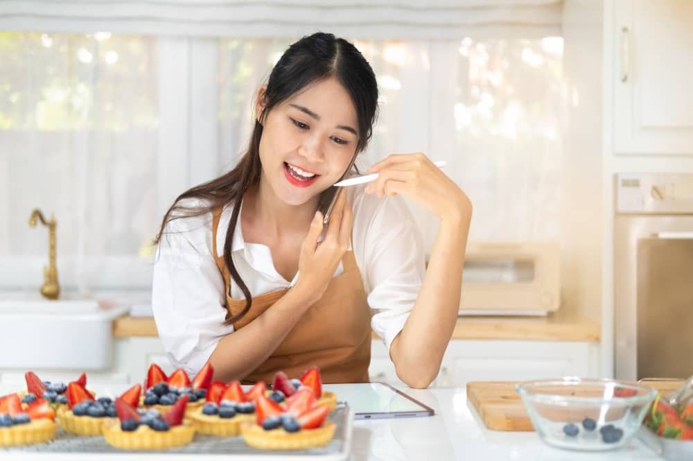 Side hustle - woman baking fruit tarts to sell.