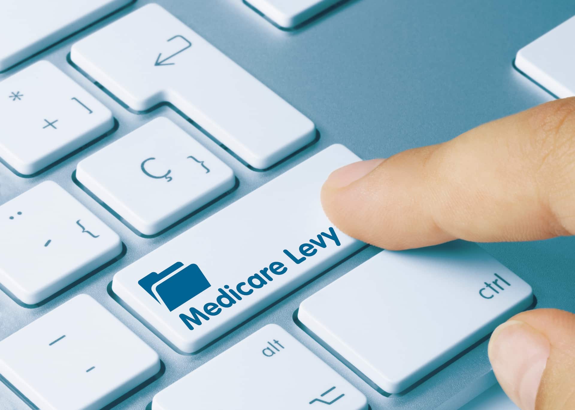 Finger pressing enter key on keyboard that is labelled Medicare Levy Thresholds